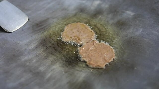 Cooking indian style mutton galouti kabab on a big pan or tawa.