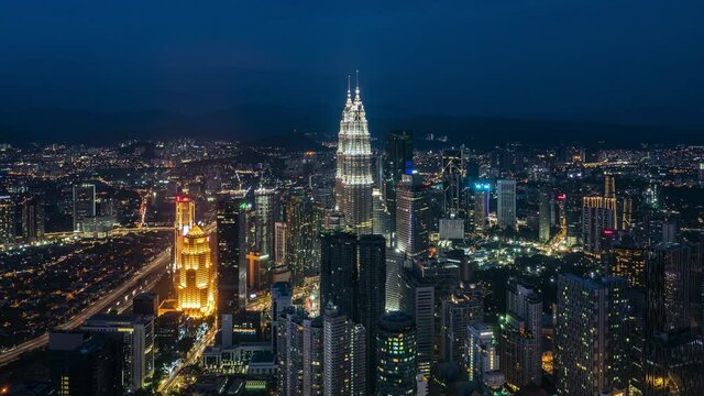 Kuala Lumpur, Malaysia, time lapse view of cityscape including national landmark Petronas Towers and modern buildings in the financial district at night.