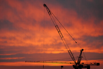 Fototapeta premium Silhouette Construction worker of Building crane on construction site background.