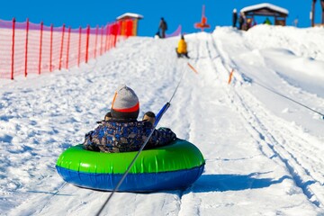 Child on a mountain lift for sledding and snow tubing