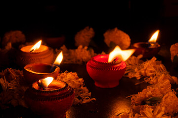 Very low angle view of Rangoli flowers and candles or diyas, Deepawali lights at night. Dark background stock image.