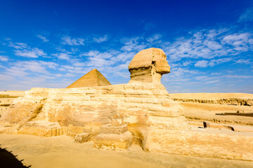 Fototapeta na wymiar It's Great Sphinx of Giza, a limestone statue of a mythical creature with a lion's body and a human head), Giza Plateau, West Bank of the Nile, Giza, Egypt