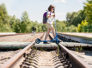 Crossing the railway tracks made of wood across the railway tracks  in the daytime. Schoolgirl ...