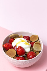 Homemade cereals mini pancake with yogurt, honey and strawberries on colorful background.