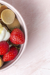 Homemade cereals mini pancake with yogurt, honey and strawberries on colorful background.