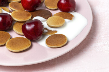 Obraz na płótnie Canvas Homemade cereals mini pancake with yogurt, honey and strawberries on colorful background.