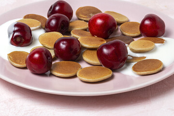 Homemade cereals mini pancake with yogurt, honey and strawberries on colorful background.