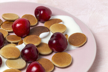 Homemade cereals mini pancake with yogurt, honey and strawberries on colorful background.
