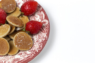 Homemade cereals mini pancake with yogurt, honey and strawberries on colorful background.