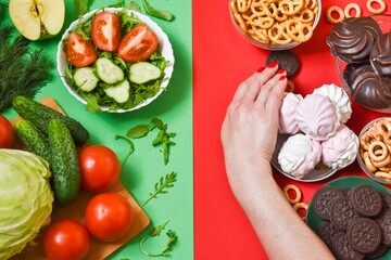 Healthy eating concept. Fruits against sweets and junk food on a red-green background. concept of choosing the right nutrition. view from above.
