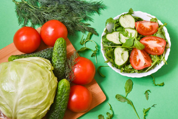 Healthy eating tomatoes, cabbage, cucumbers, arugula on a green background.Diet concept.