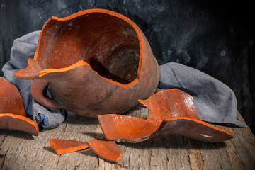Broken clay jug on a wooden table