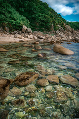 View of the seashore with large stones and marine life under water