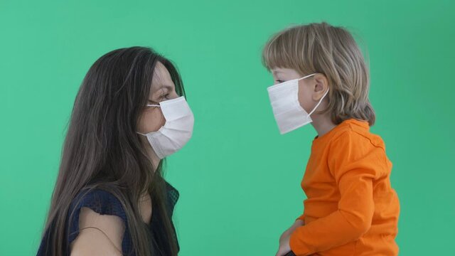 Mother and child using face mask talk and kiss, love and relationship in new global health situation, adapting to new lifestyle