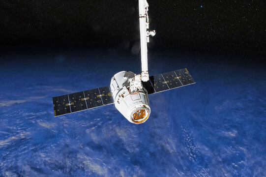 SpaceX Crew Dragon spacecraft docking to the International Space Station. Dragon is capable of carrying up to 7 passengers to and from Earth orbit, and beyond. Elements of this image furnished by NASA