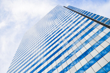 Modern business office building with glass windows reflect the skyline that view from below in Bangkok, Thailand.