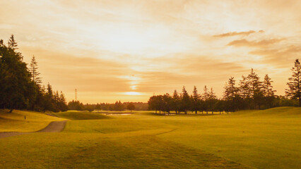 芝生の色をすっかり茶色に変えてしまった夕日があたるゴルフコース