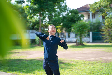 Portrait of Asian woman workout before running at village park.