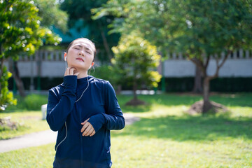 Portrait of Asian woman wearing earphones listening to music was sick with irritate itching her skin at park