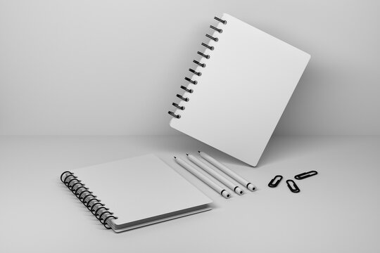 Template mockup with two office spiral notebooks sketchbooks, three carbon pencils and paper pins on white background