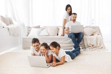 Large family with gadgets. Children and parents at home with a laptop. 
