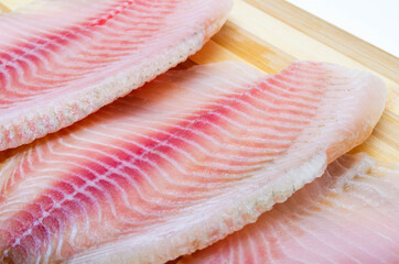 Two filet fish hare, rabbit fish on a cutting board in macro. Dorado fillet, telapia. Raw fish, seafood in macro. Top and side view