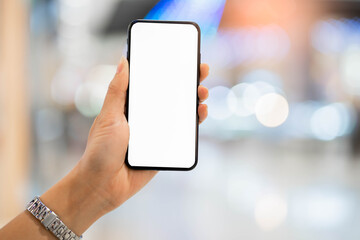Women hand holding mobile phone blurred bokeh background.