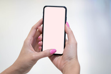Woman hand holding mobile phone. Selective Nail Polish touching on blank screen phone white background.
