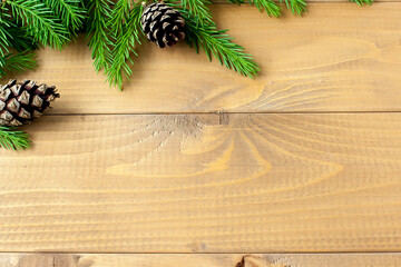Green spruce branches on a light wooden background. Fake artificial spruce branch on a wooden table made of planks.