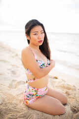 Gorgeous young asian girl posing emotionally with sea waves and horizon on background. Pretty dark-haired girl in sunglasses expressing happiness.
