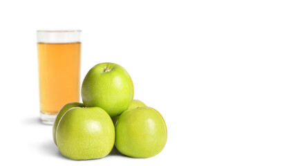 Ripe green apples and a glass of juice on a white isolated background with text space.