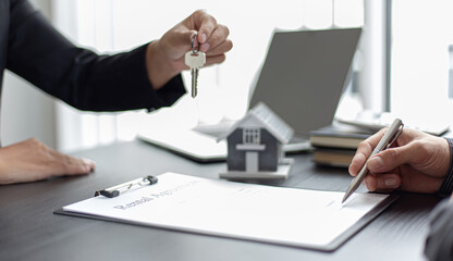 Young woman handed the house key to the young man.