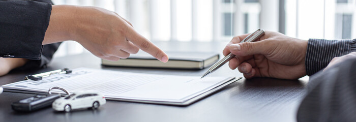 Asian businessmen ask customers to sign insurance documents.