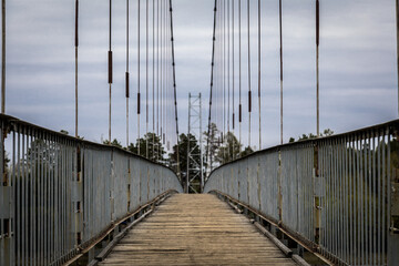 Obraz premium old suspension bridge made of metal and wooden planks