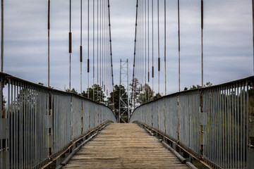 old suspension bridge made of metal and wooden planks