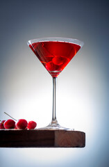 fresh red cherry juice in a wine glass with red cherries 