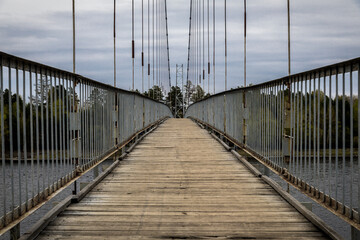 old suspension bridge made of metal and wooden planks