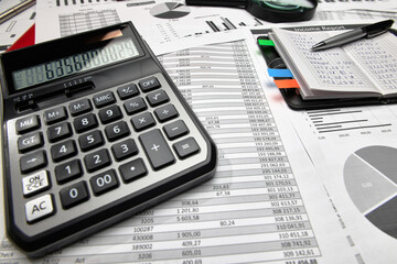 Top view of office employee's desk - work with financial reports, analysis and accounting, tables and graphs, various office items for bookkeeping