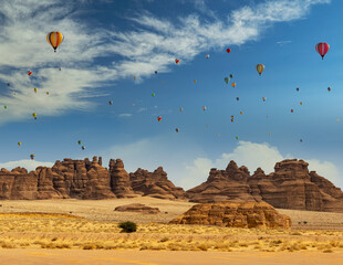 Hot air balloons behind outcrops at Mada'in Saleh archaeological site near Al Ula, Saudi Arabia