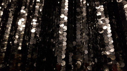 Glowing black silver sequins background with copy space
