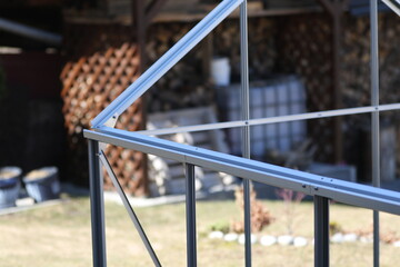 Fototapeta na wymiar Folding and assembling a hothouse- greenhouse in the garden. Individual assembly steps. Greenhouse construction.