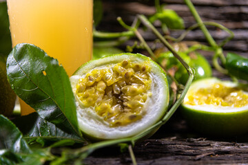Passion fruit juice and fruits on wooden background