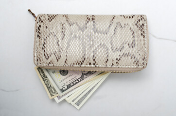 Top view of female modern purse full of money on the white marble table