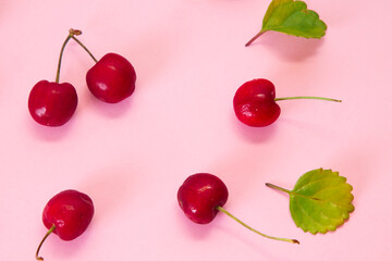 delicious red cherries on pink background