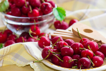 plate of delicious red cherries on the table with tablecloth