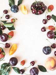 Various berries and fruits on a white background. Frame of strawberries, cherries, peach, plum. Copy space