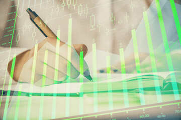 Multi exposure of woman's hands making notes with forex graph hologram. Concept stock market analysis.