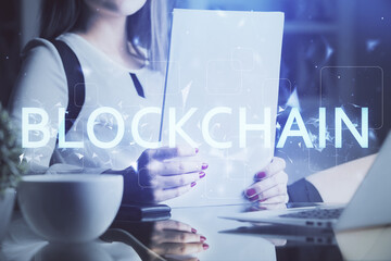 Cryptocurrency hologram over woman's hands writing background. Concept of blockchain. Double...