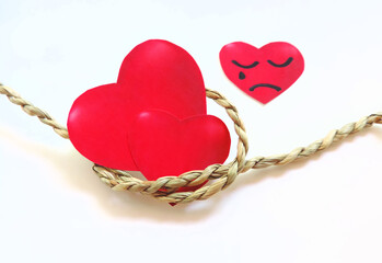 two red hearts tied with one rope a third heart a sad face