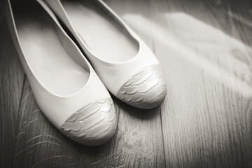 Morning of the bride, white shoes lying on the floor